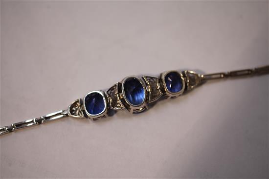 An early 20th century white metal and three stone sapphire bracelet,